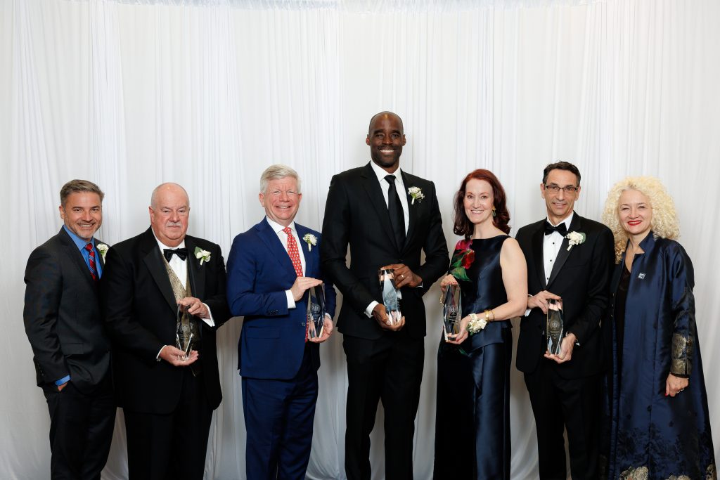 Seven people pose for a photo in dress up attire