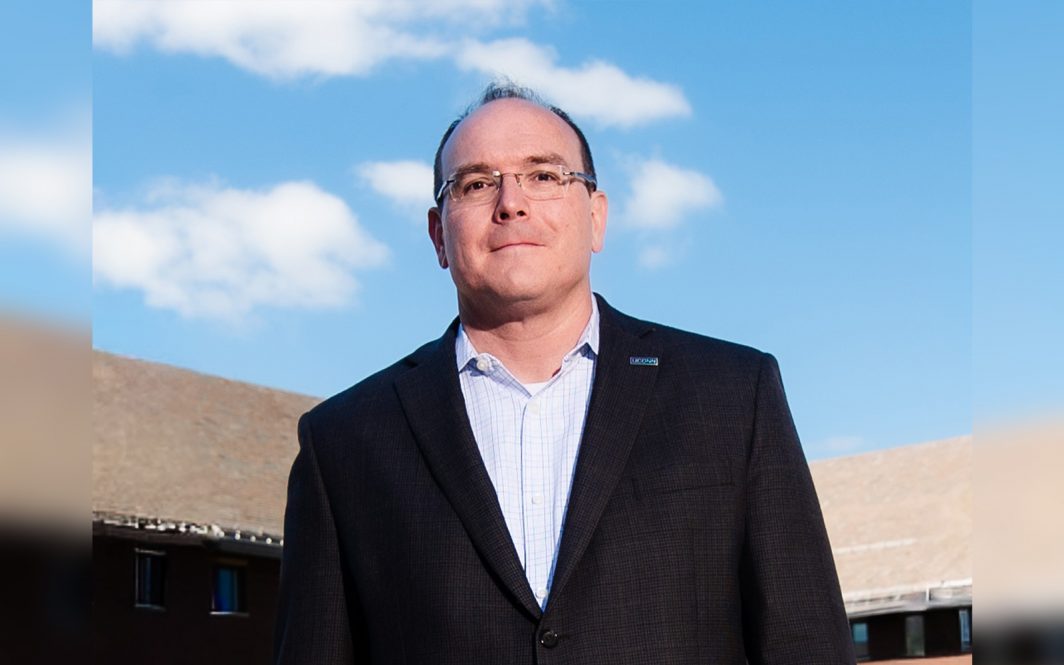 Portrait of Bob Day in from of the School of Business in Storrs, CT>.