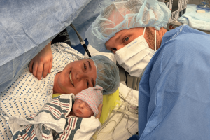 man and woman holding a baby in an operating room