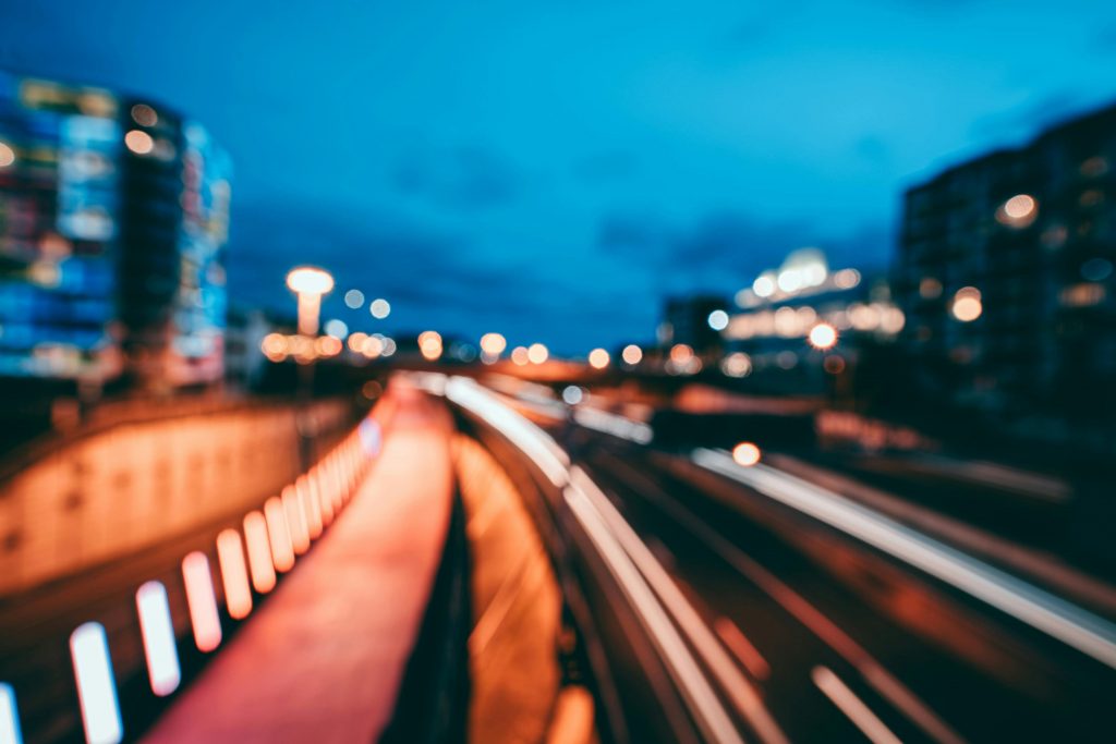 Blurry long exposure of city lights and cars driving along a road