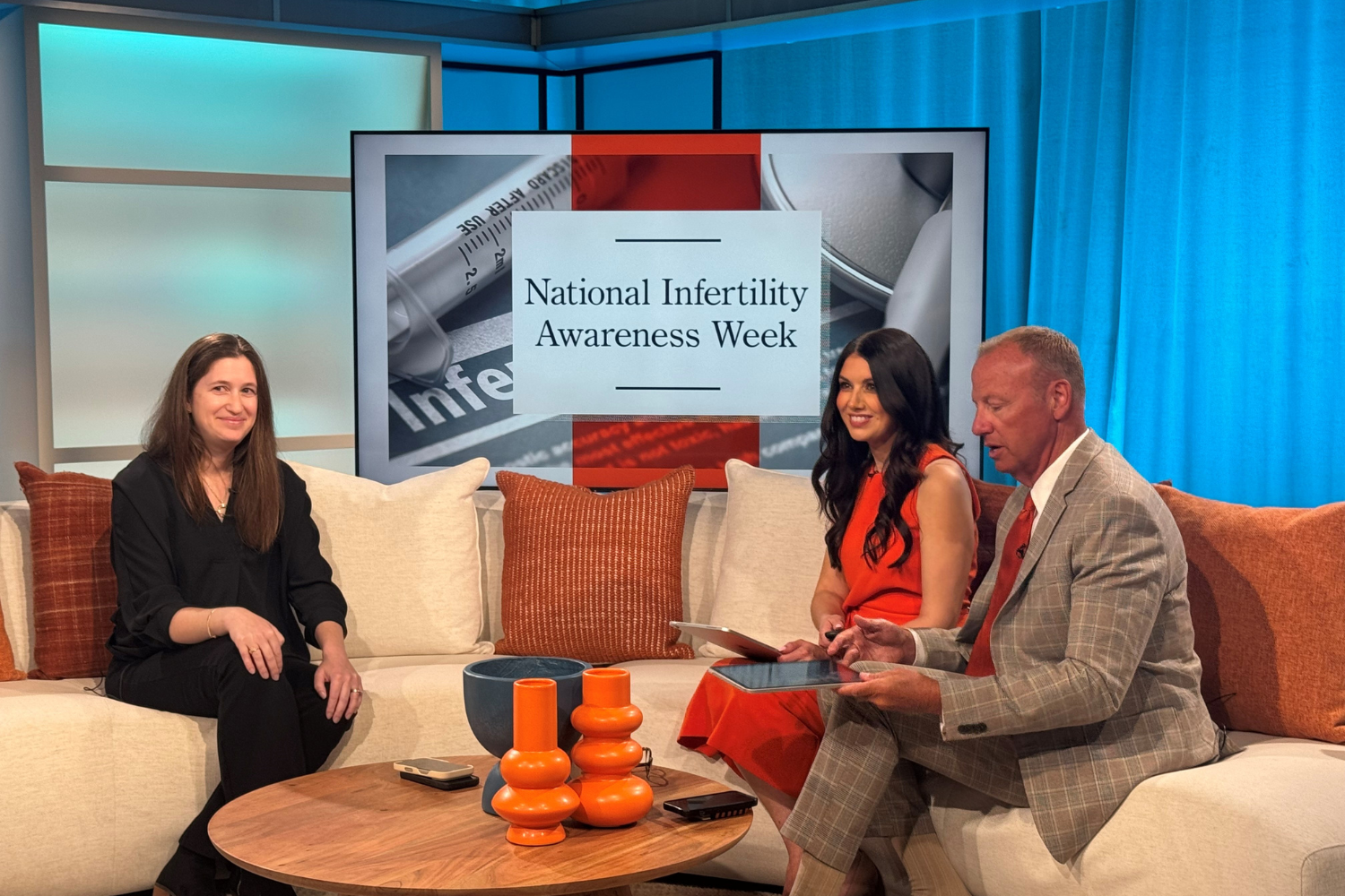 two women and a man sitting on a couch