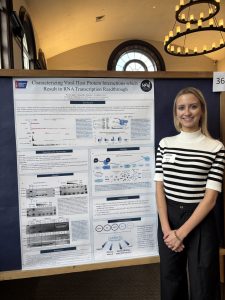 Woman poses in front of research poster.