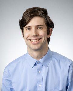 second brown haired man in blue dress shirt