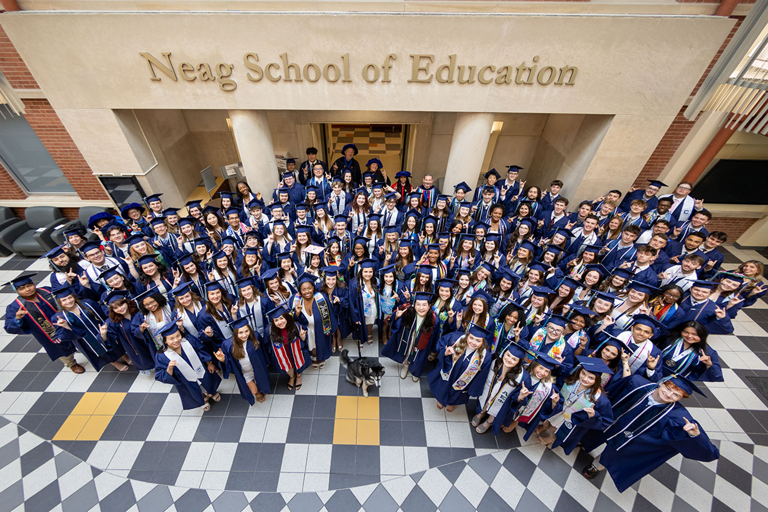 The Neag School's Class of 2026 stands as a group in the Gentry Building atrium.