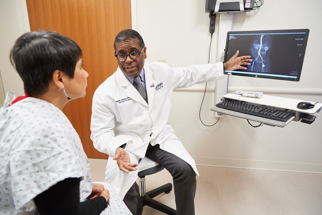 physician explains imaging to patient in exam room