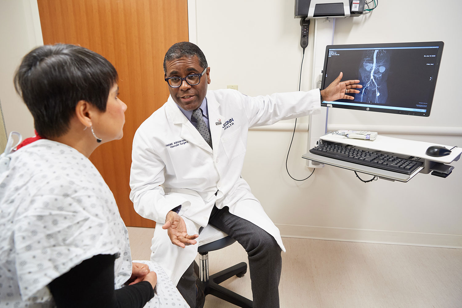 physician explains imaging to patient in exam room