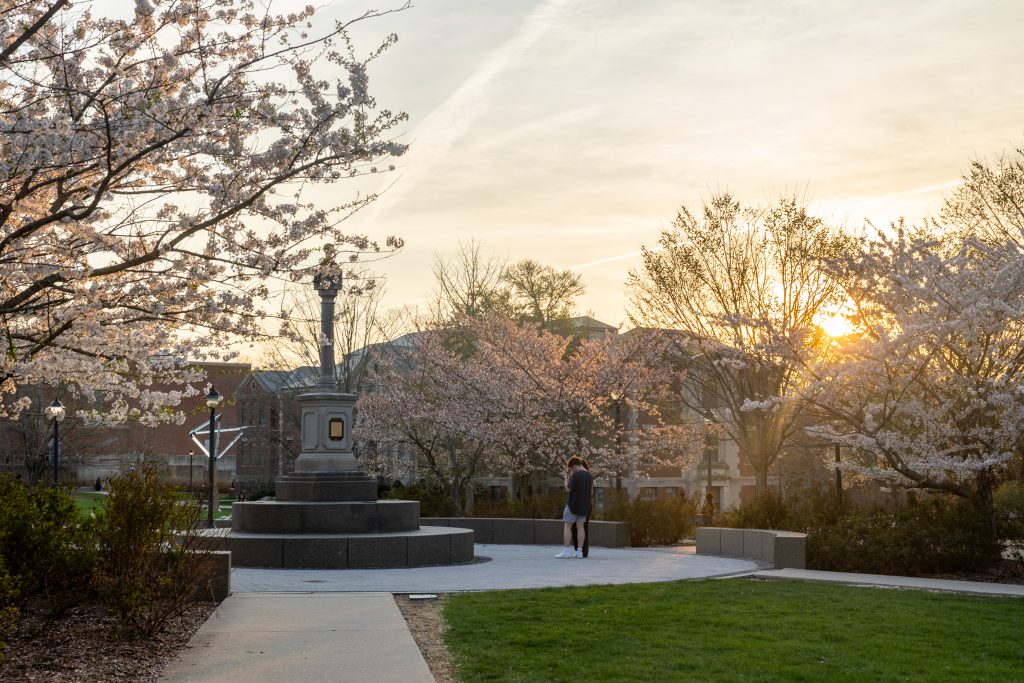 Sunset on campus with spring blooms and a sundial