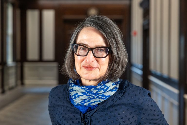 A woman in glasses and a scarf posing for a photo