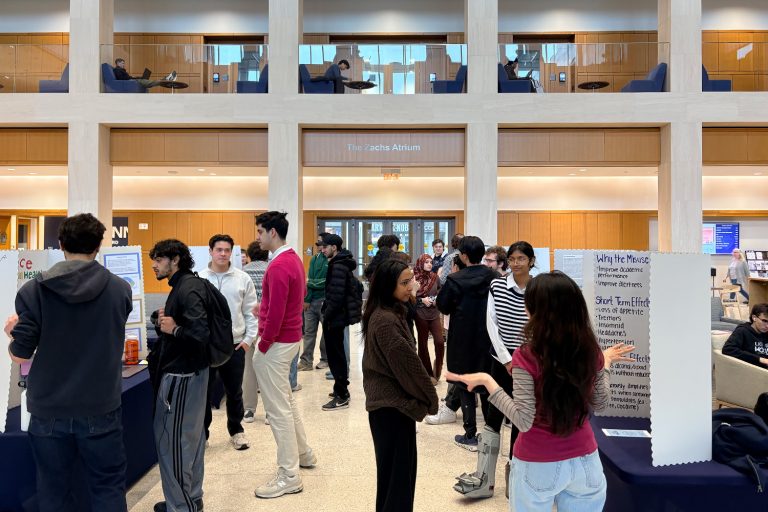 Students present their research to fellow students at a poster presentation in the Zachs Atrium at UConn Hartford