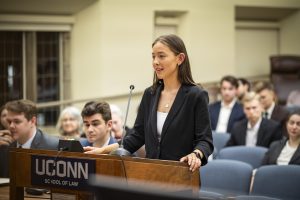 A woman who is a law student stands at a podium.