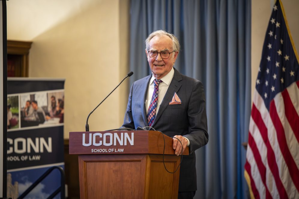 A man in a suit makes remarks from a podium.