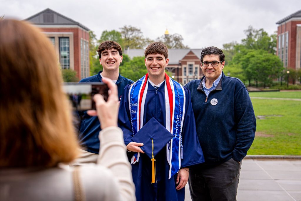 Male graduate and loved ones pose before 2026 CAHNR Commencement