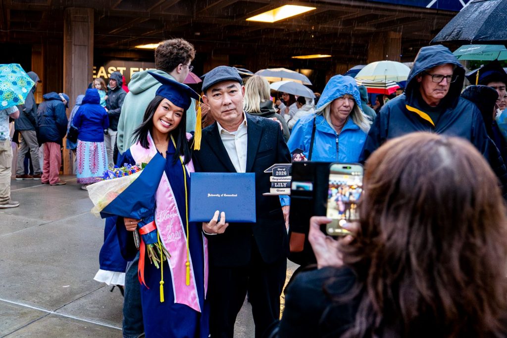 A CAHNR graduate stands with a family member after commencement