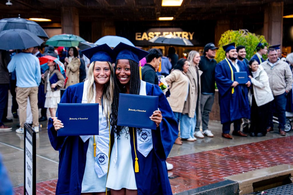 Two CAHNR graduates pose with diplomas after commencement
