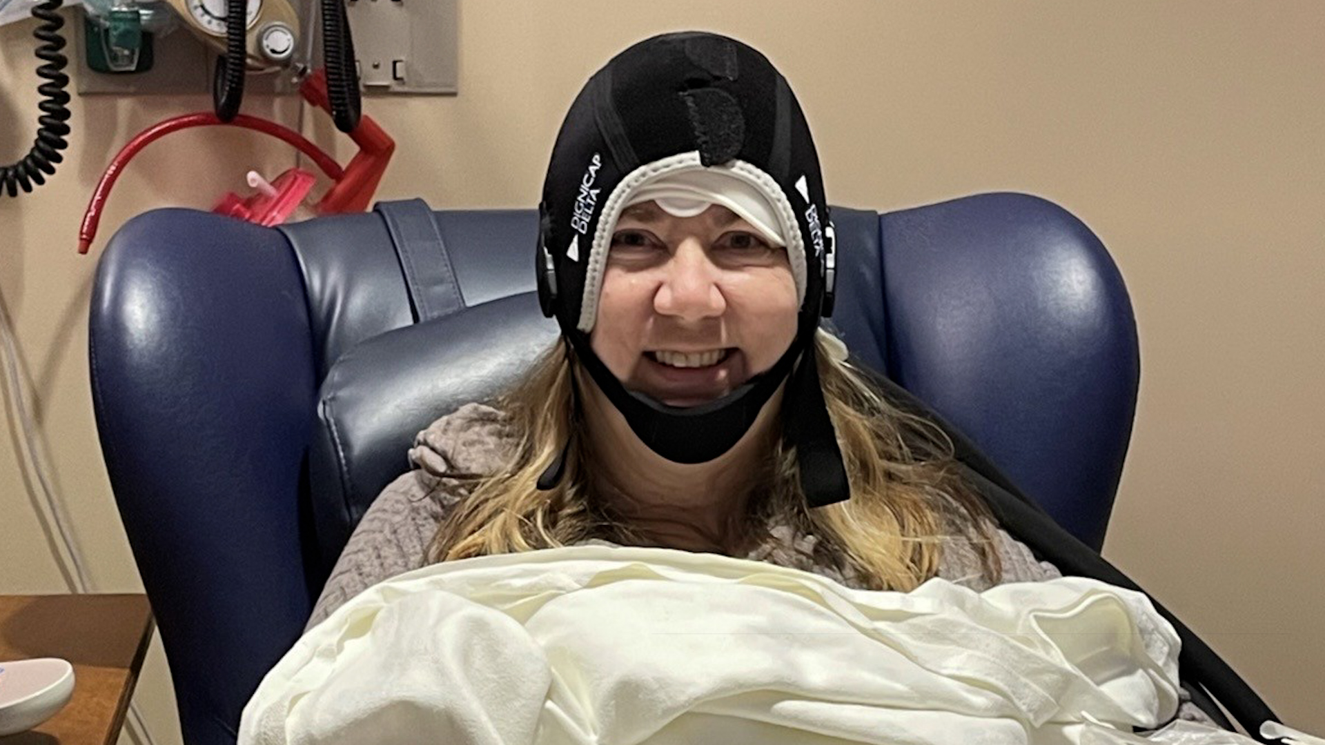 Cancer patient Cheryl Hill using the DigniCap scalp cooling therapy while receiving a chemotherapy infusion at the Neag Comprehensive Cancer Center at UConn Health. (Photo courtesy Cheryl Hill)