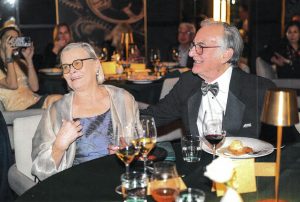 A woman and a man in formalwear sit at a table.