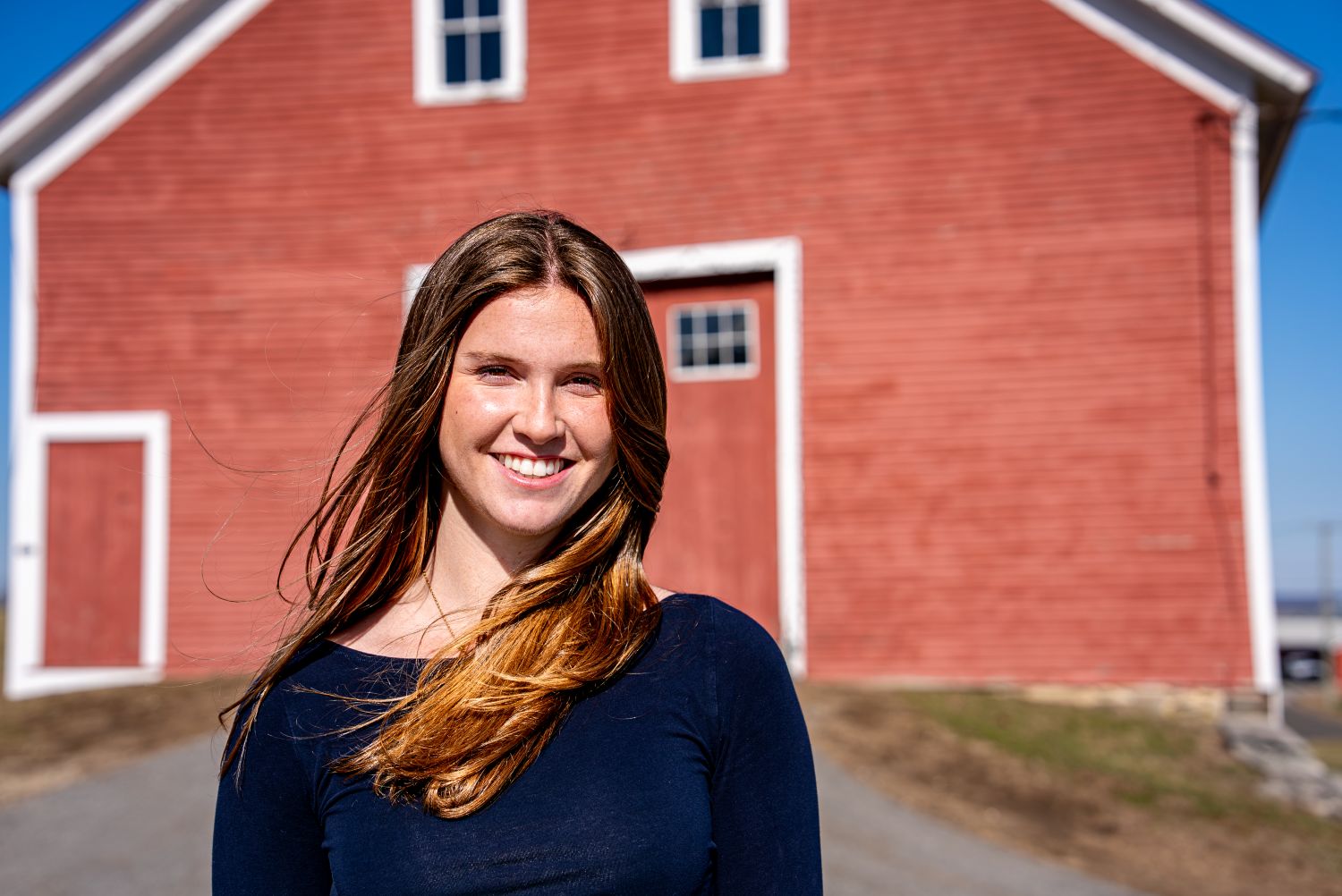 Sofie Jepsen ‘26 (CAHNR), an agricultural and resource economics major poses for a photo outside Jacobson Barn
