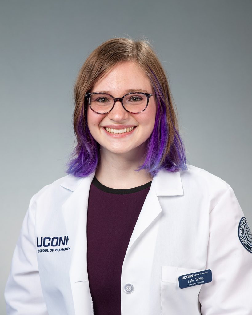Headshot of girl in lab coat with purple hair