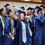 Graduates pose for a selfie.