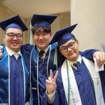 Three graduates pose together.