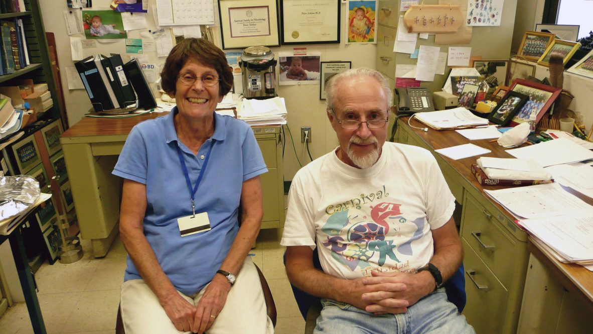 A woman and a man, a married couple, sitting next to each other in an office.