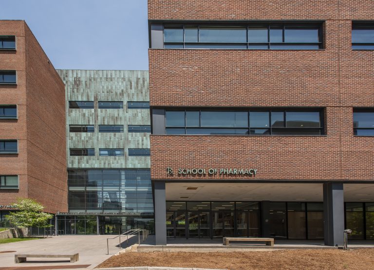 Photo of the front of the UConn Pharmacy and Pharmaceutical Sciences building during day time