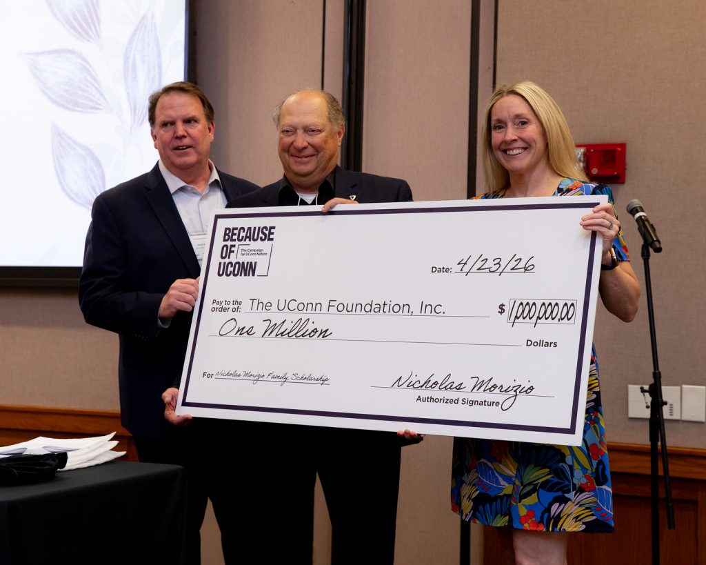 Three people hold a large novelty check for $1 million.