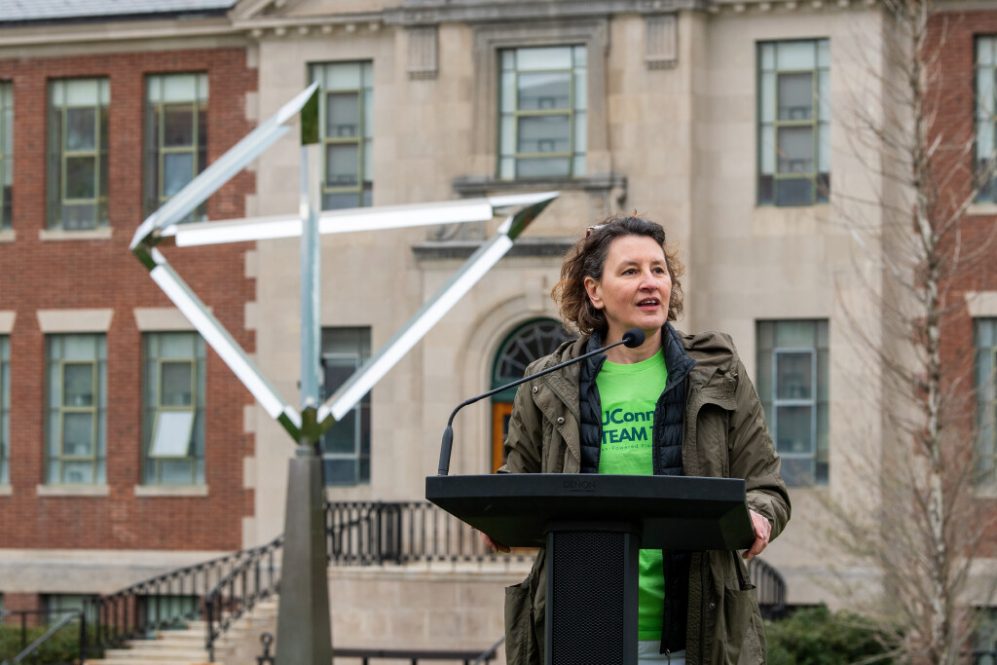 Jasna Jankovic speaks at a podium during a UConn event outdoors.