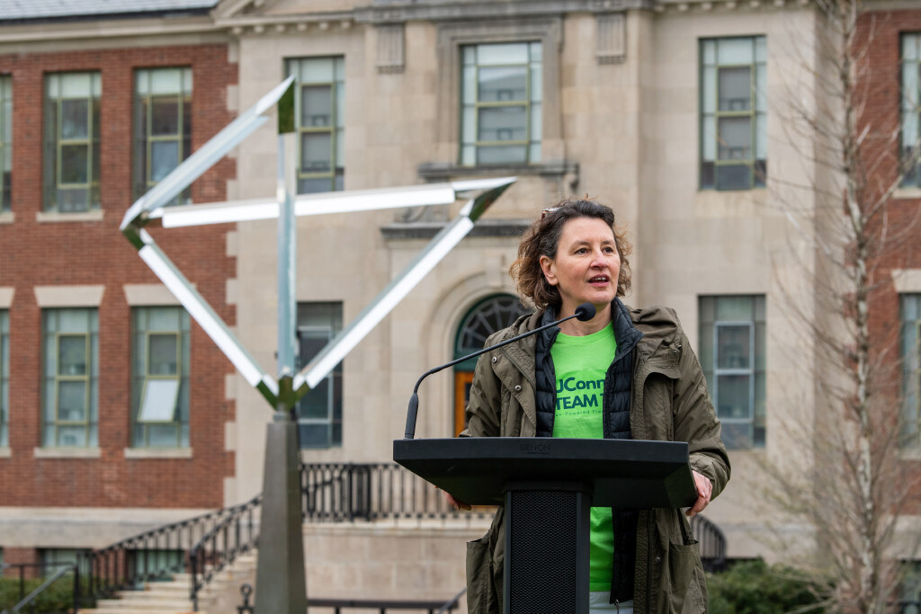 Jasna Jankovic speaks at a podium during a UConn event outdoors.