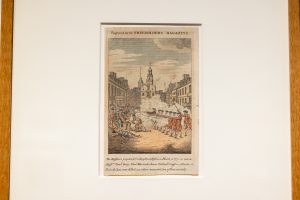 A political print by Paul Revere of the Boston Massacre hanging on a wall