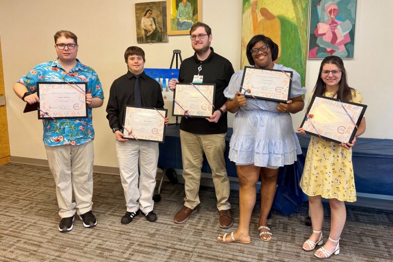 Group portrait of five holding certificates