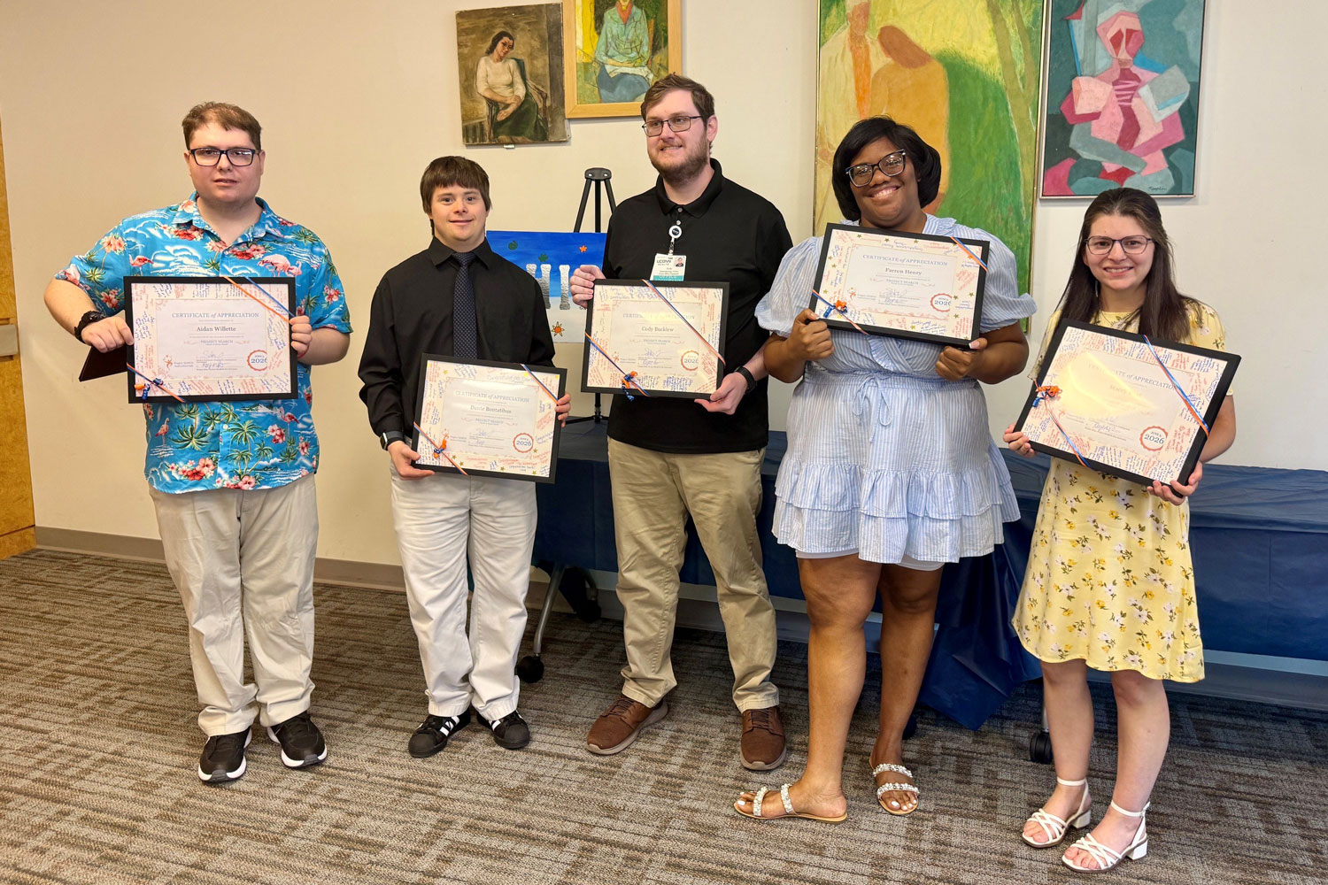 Group portrait of five holding certificates