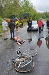 Law enforcement personnel reviewing the scene of a simulated car crash.