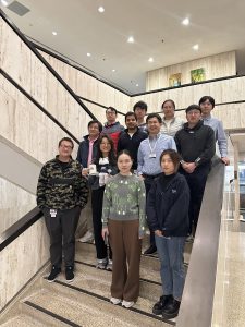 Research team members pose together on a staircase inside a campus building.