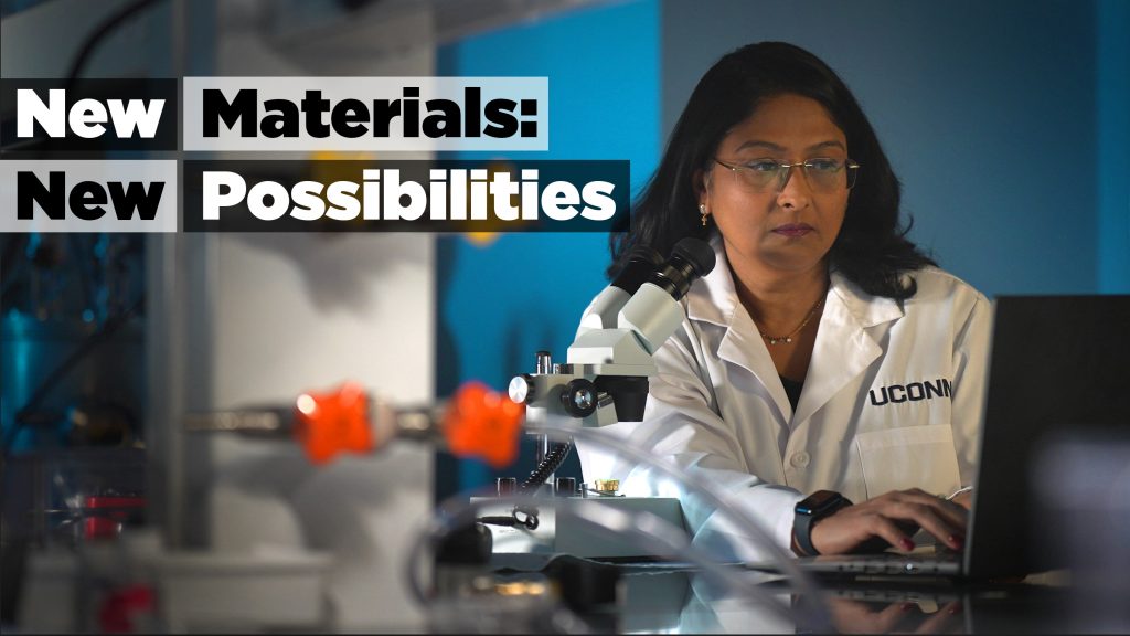 A woman in a white lab coat sitting at a computer with the words "New Materials: New Possibilities" overlayed on the photo