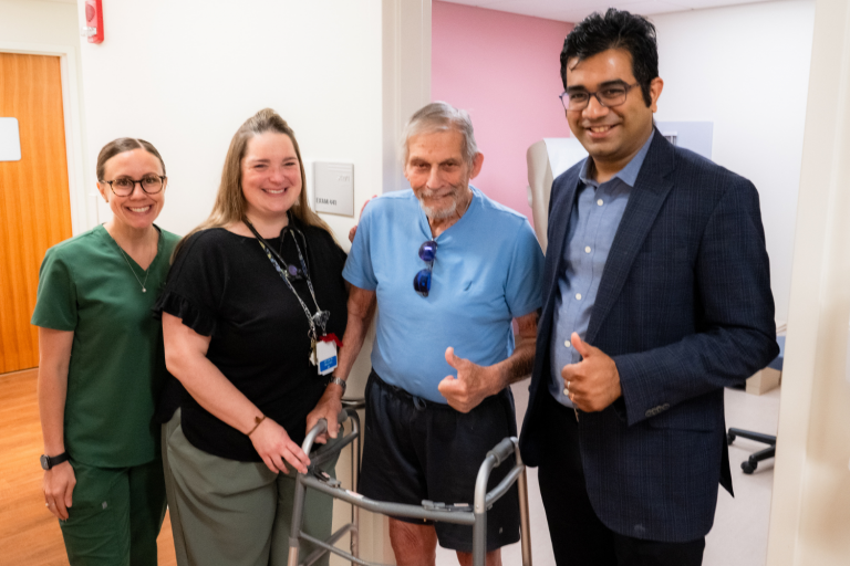 two women and two men standing giving a thumbs up