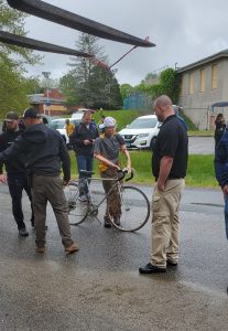 Law enforcement personnel setting up a bicyclist dummy before a car crash.