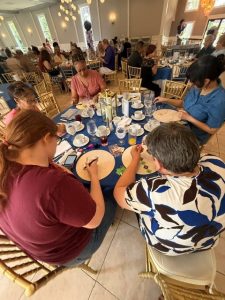 women sitting at a table painting