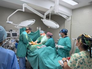 5 people in scrubs in a surgery room 