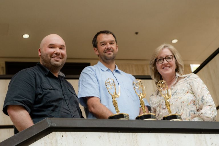 portrait of three with Emmy Awards