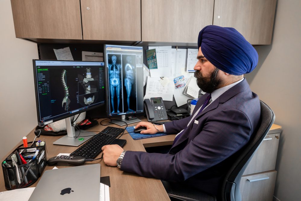 UConn Health spine surgeon Hardeep Singh reviewing digital images for an upcoming spinal surgery. (Tina Encarnacion/UConn Health photo)