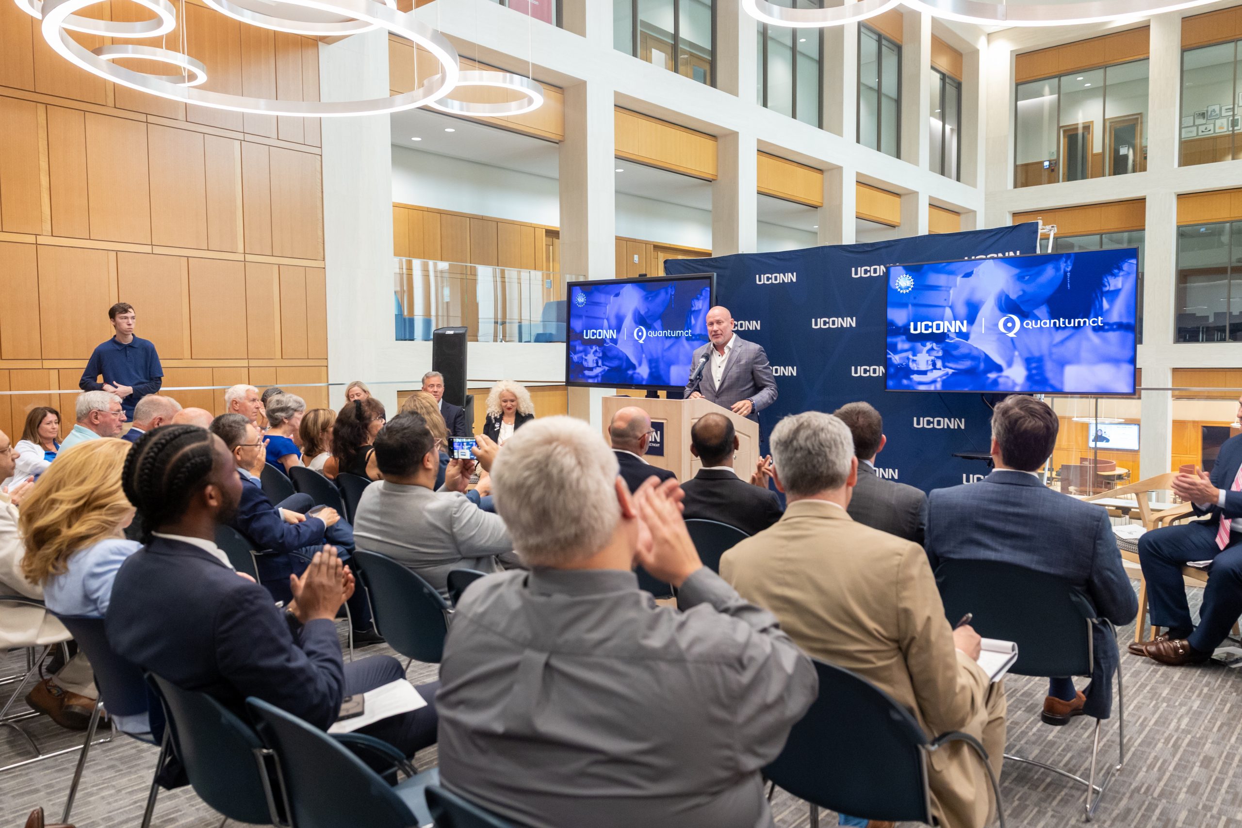 A man at the podium speaking to an audience