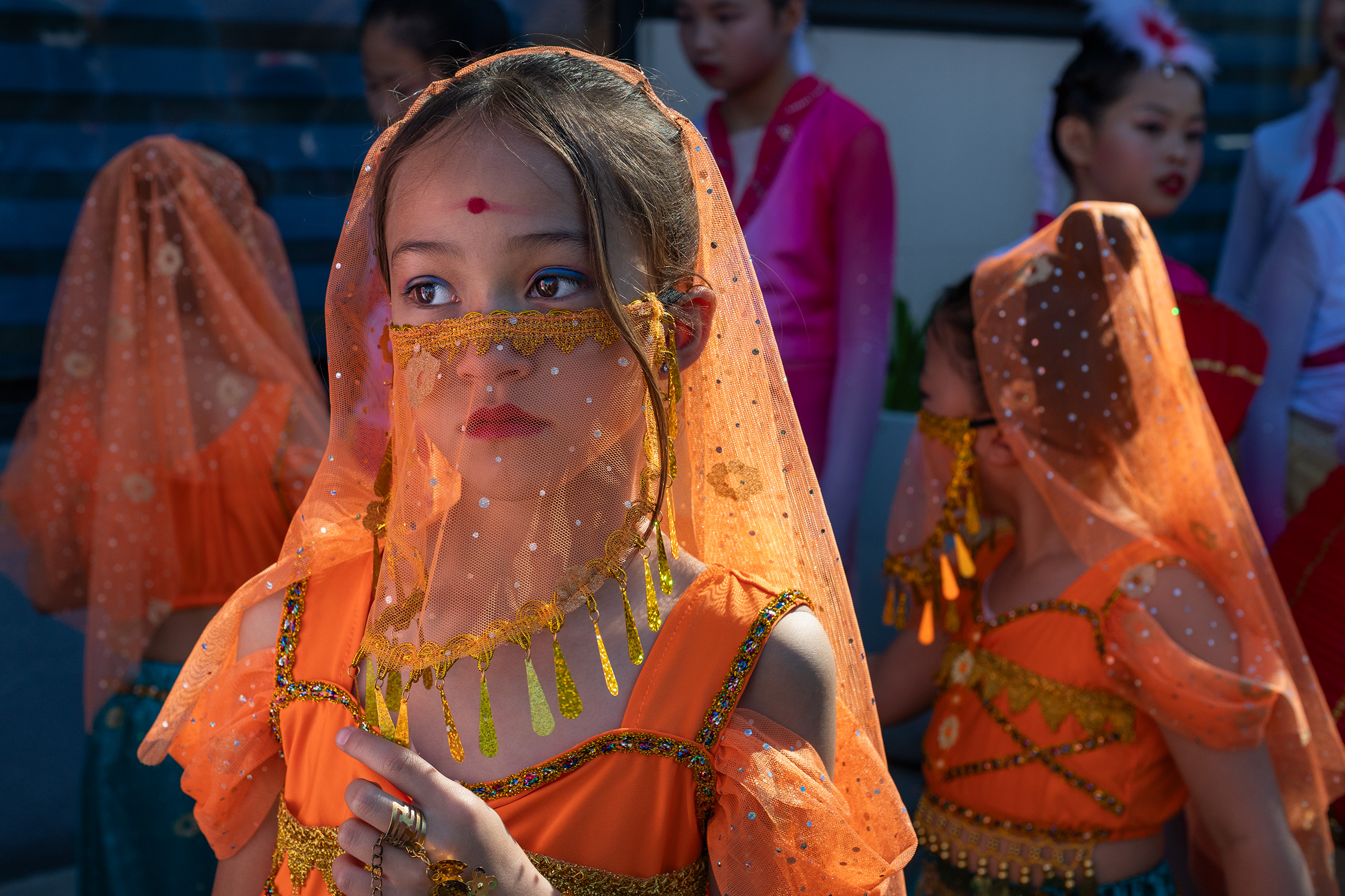 A young girl dressed in orange for the Lunar New Year