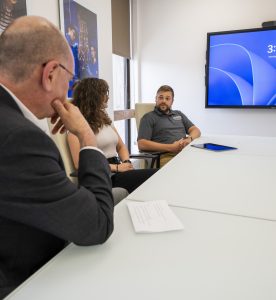 Three people sitting at a table talking