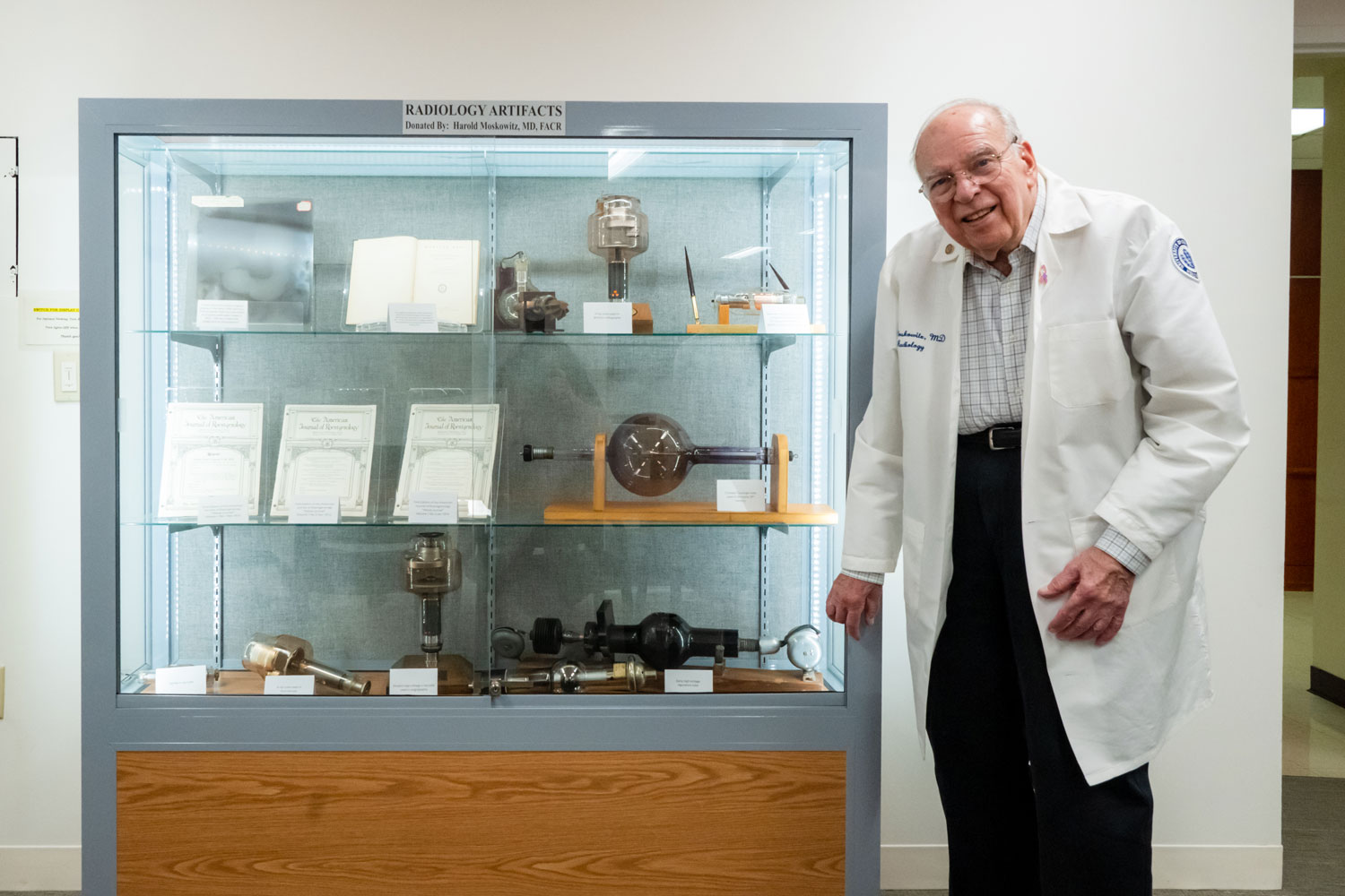 Dr. Harold Moskowitz next to a case of radiology artifacts
