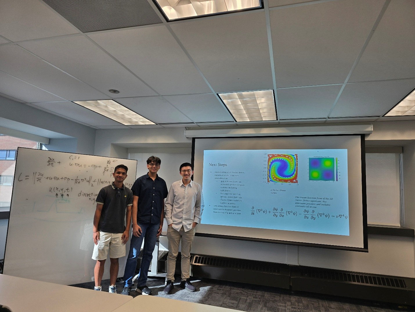 Three students present computational engineering research in a classroom.