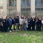 A large group photo of project participants in a courtyard.