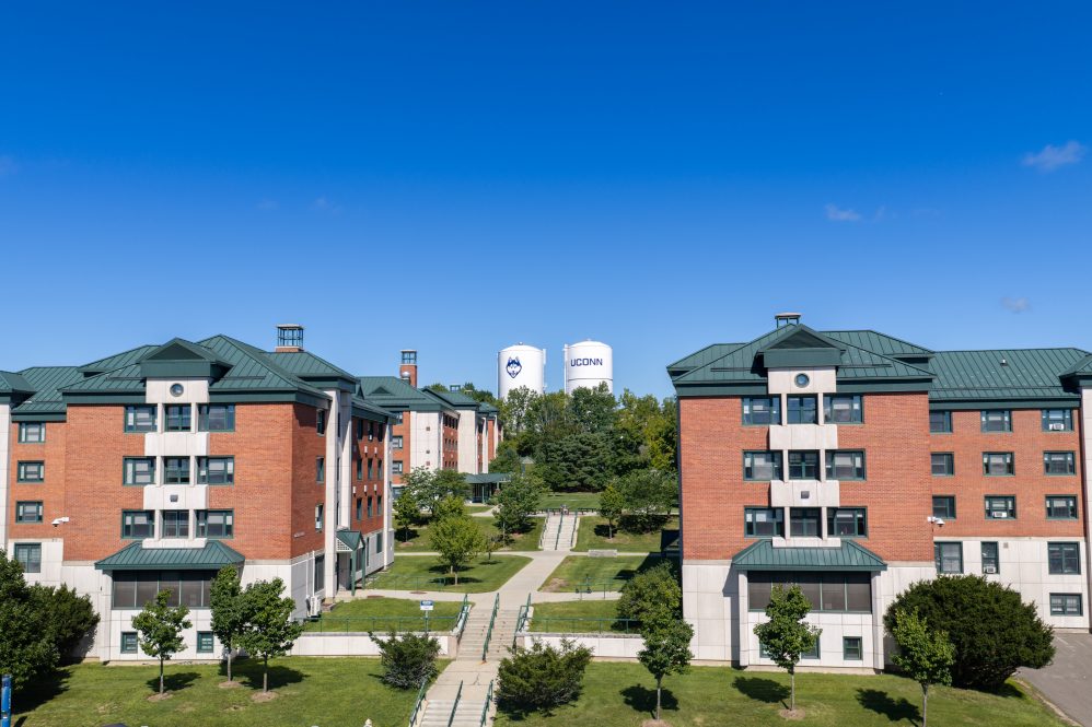 The Towers Residence Halls and UConn water towers sit under a blue sky