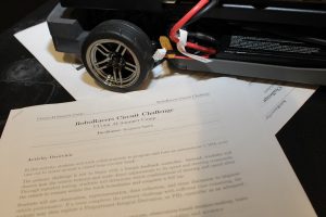 A close-up photo of a toy car and an instruction manual to build it.