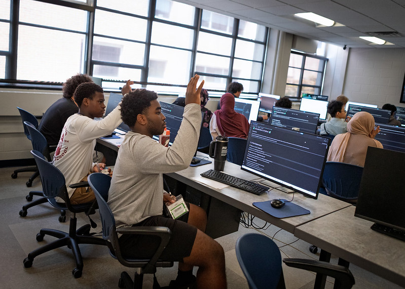 Students learning Python in a classroom.